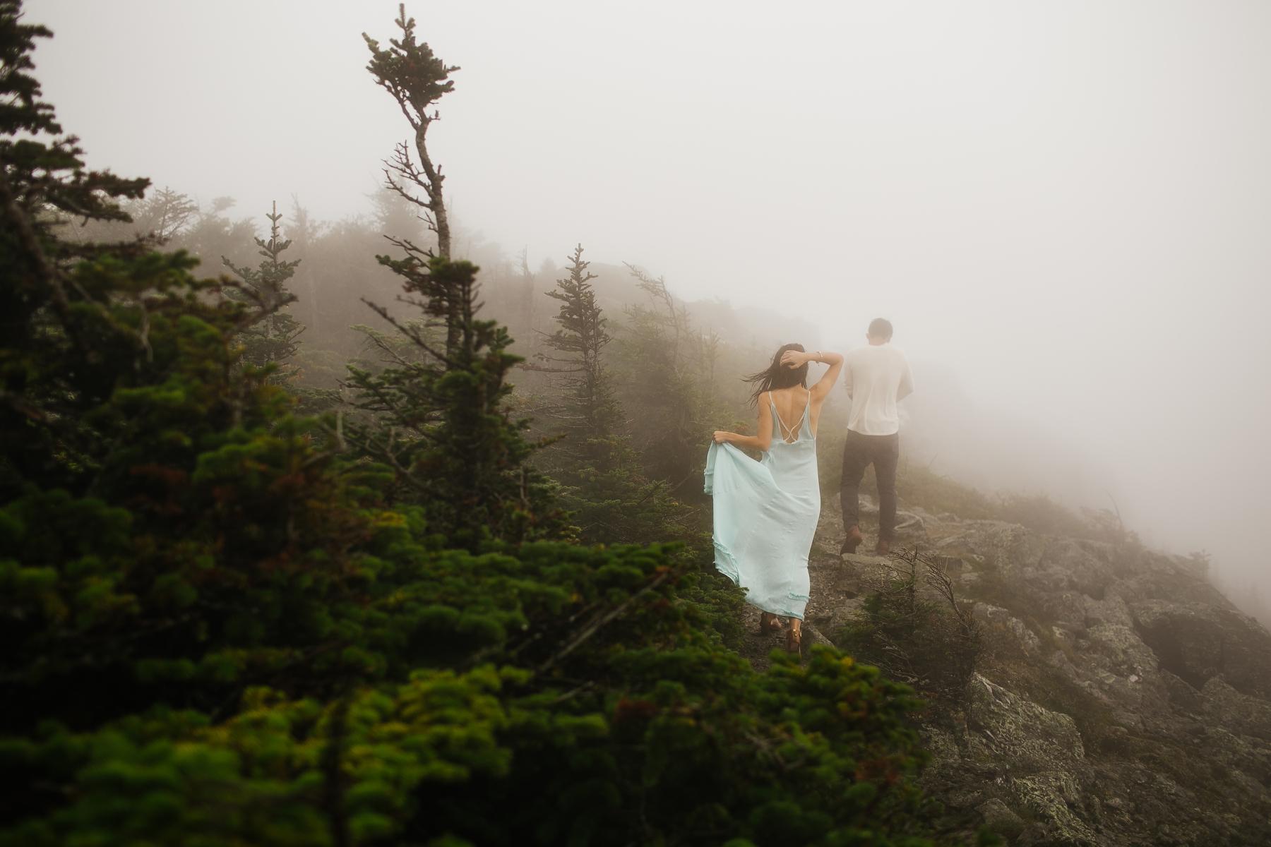 Couple walking on a path in the fog on Mt. Mansfield near Stowe, Vermont.